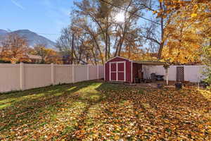 Fenced backyard featuring a storage unit and a mountain view