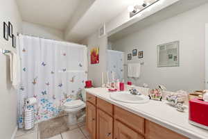 Bathroom featuring light tile patterned floors, vanity, and shower