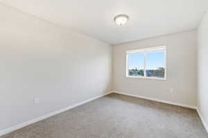 Carpeted empty room with baseboards