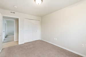 Unfurnished bedroom featuring carpet and a closet
