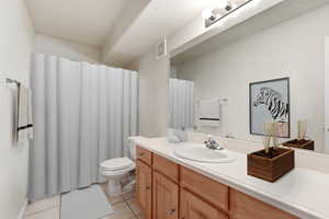 Bathroom with vanity, a shower with curtain, and light tile patterned floors
