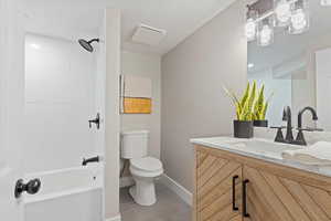 Full bath featuring vanity, light tile patterned floors, bathing tub / shower combination, and a textured ceiling