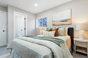 Carpeted bedroom with connected bathroom and recessed lighting