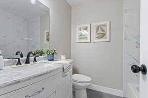 Bathroom with vanity, dark wood-type flooring, and shower / bath combination