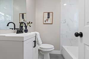 Full bathroom with vanity, shower / bathtub combination, and dark wood-type flooring