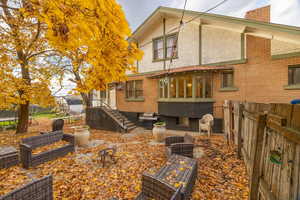 Rear view of house with a fenced backyard, stucco siding, and brick siding