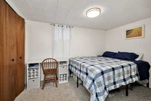 Bedroom featuring carpet flooring and wooden walls