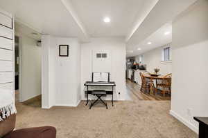 Sitting room with light carpet and recessed lighting