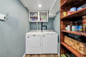 Laundry area featuring wood finished floors and washing machine and clothes dryer