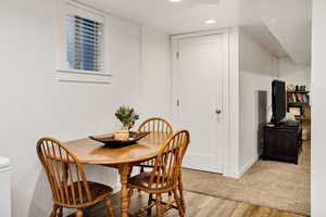 Dining area with light wood finished floors and recessed lighting