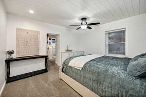 Carpeted bedroom with a walk in closet, wood ceiling, ceiling fan, and recessed lighting