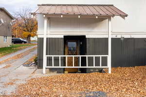 Rear view of house featuring a metal roof