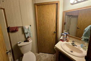 Full bathroom with wallpapered walls and vanity