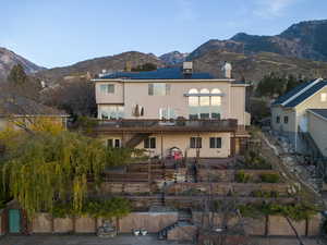 Back of property featuring stairs, a chimney, and a mountain view