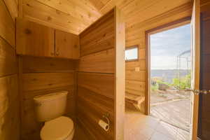 Bathroom featuring a sauna, light tile patterned floors, wood walls, and wood ceiling