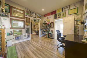 Office with light wood-type flooring and recessed lighting