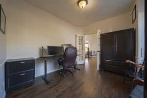 Office space featuring dark wood flooring and baseboards