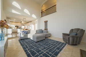 Living room featuring a towering ceiling and light tile patterned floors