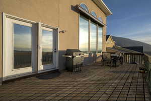 Wooden deck with a mountain view, a grill, and outdoor dining area