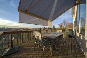 Wooden terrace featuring outdoor dining space and a mountain view