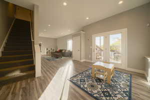 Living room with stairway, recessed lighting, and light wood-type flooring