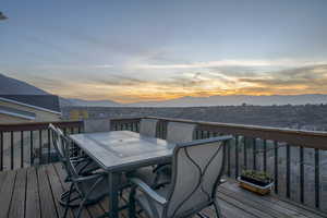 Deck at dusk featuring outdoor dining space and a mountain view