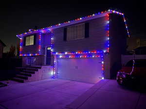 Bi-level home featuring a garage, driveway, and brick siding