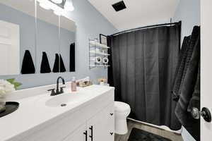 Bathroom with a tub/shower with shower curtain, light wood-style flooring, and vanity