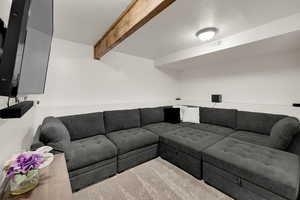 Carpeted living room with beam ceiling and a textured ceiling