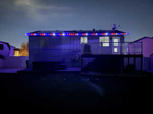 View of front of property featuring a wooden deck and stairs