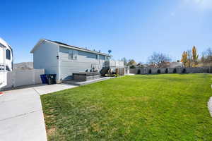 Rear view of house featuring a fenced backyard, a patio area, a deck, stairs, and a hot tub