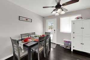 Dining room featuring dark wood-type flooring and ceiling fan