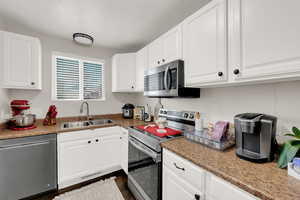 Kitchen featuring stainless steel appliances and white cabinetry