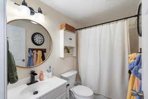 Full bath with shower / bath combo with shower curtain and vanity