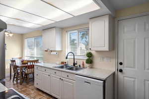Kitchen with light countertops, appliances with stainless steel finishes, and white cabinets