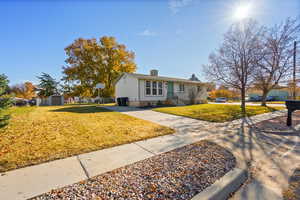Single story home featuring a chimney and a storage unit