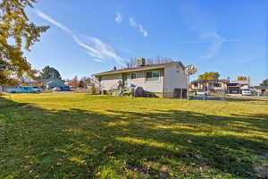 Rear view of house featuring a fenced backyard, a chimney, and a gate