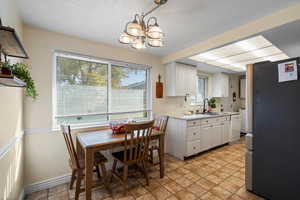 Dining area featuring light stone finish floors and a chandelier