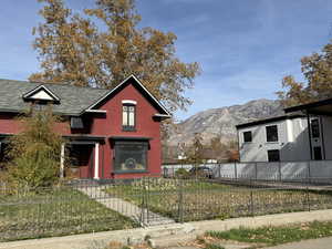 View of front facade featuring a fenced front yard, brick siding, and a mountain view