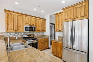 Kitchen featuring stainless steel appliances, recessed lighting, tasteful backsplash, brown cabinets, and light tile patterned floors