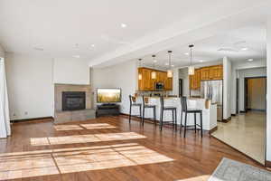 Living area featuring a tile fireplace, light wood-style flooring, and recessed lighting