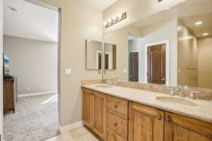 Bathroom featuring double vanity, light carpet, and light tile patterned flooring