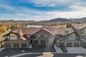 Aerial view of property and surrounding area with a water and mountain view