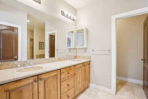 Full bathroom with double vanity, a shower stall, and light tile patterned floors