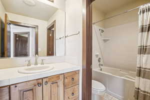 Full bathroom with shower / tub combo with curtain, vanity, and light tile patterned flooring