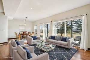 Virtually Staged. Living room with wood finished floors and recessed lighting