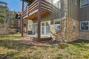 View of home's exterior featuring board and batten siding, stone siding, a deck, and a balcony