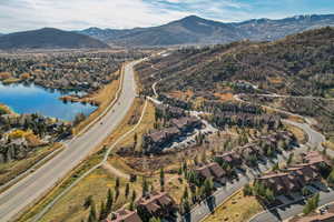 Aerial view of property and surrounding area with a water and mountain view and nearby suburban area