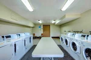 Shared laundry featuring a textured ceiling and washer and clothes dryer