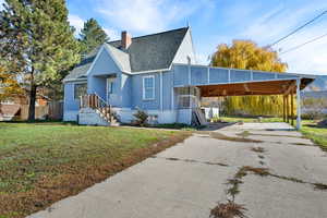 View of front of home with a chimney, a shingled roof, and driveway